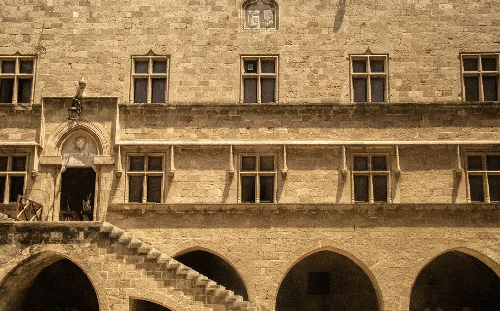 Gothic stone facade with arches and an external staircase in the medieval quarter of Rhodes