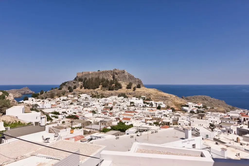 View over the white rooftops of Lindos to the Acropolis and the sea, seen from Lindos Comfy Suites