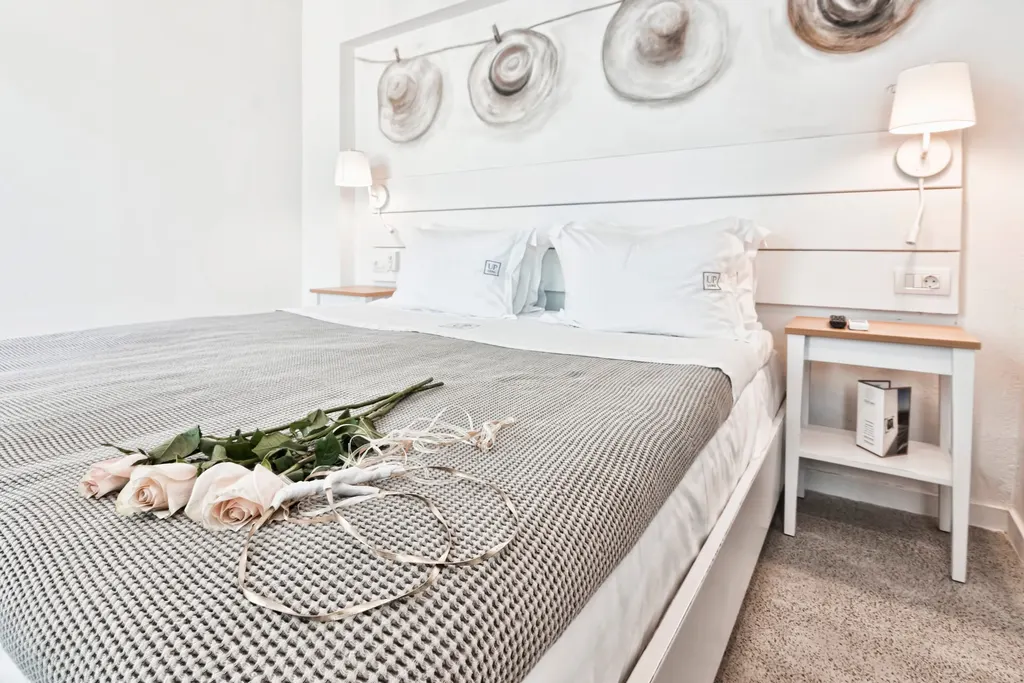 King bed with fresh roses in the Honeymoon Suite at Lindos Comfy Suites